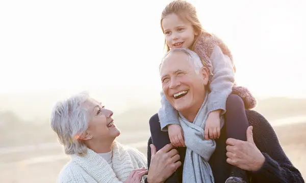Elderly man with child on shoulders, smiling